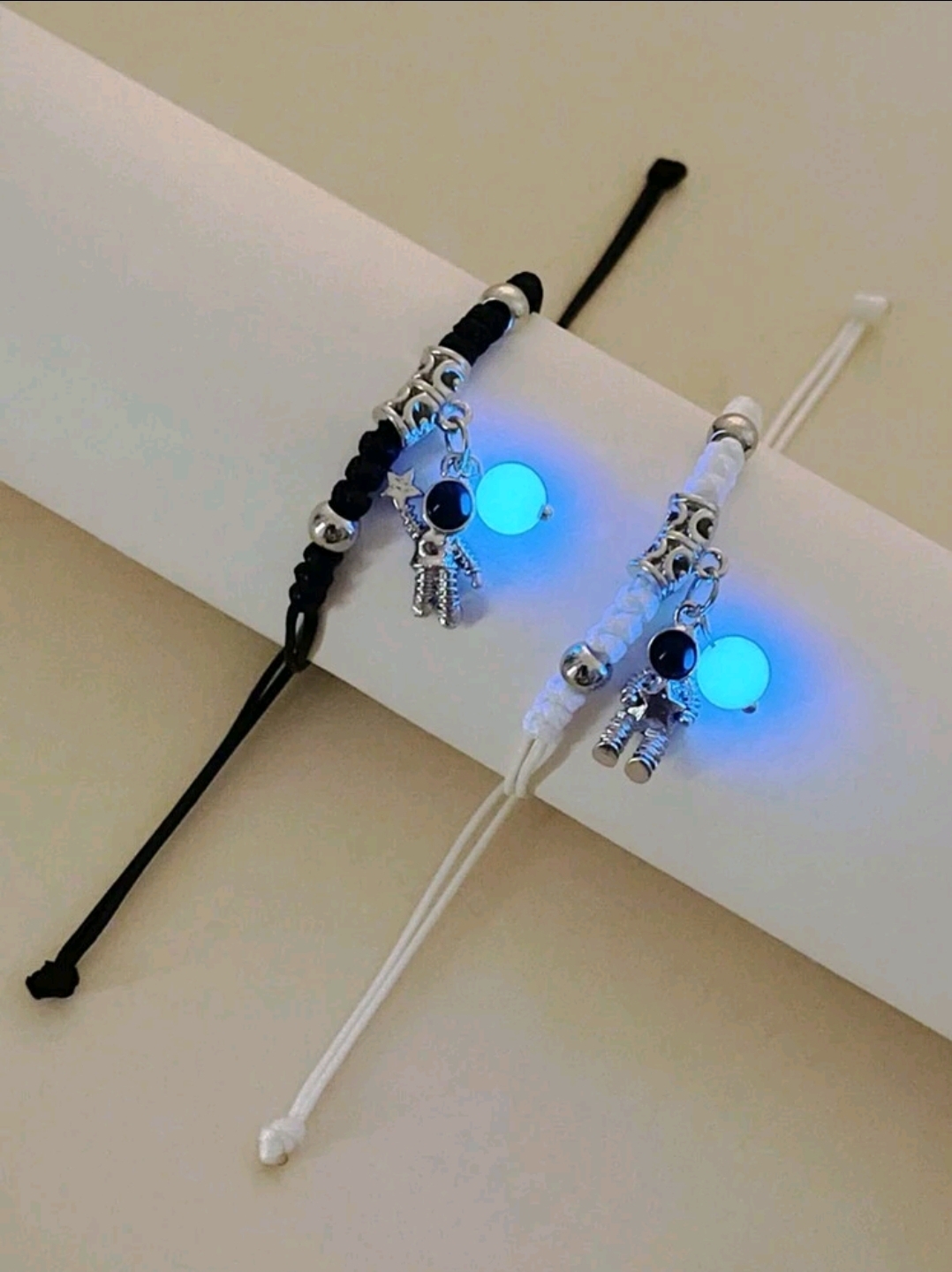 PULSERA DE CORDON DELGADO BLANCO Y NEGRO CON DIJE DE ASTRONAUTA  CON ESTRELLITAS P10